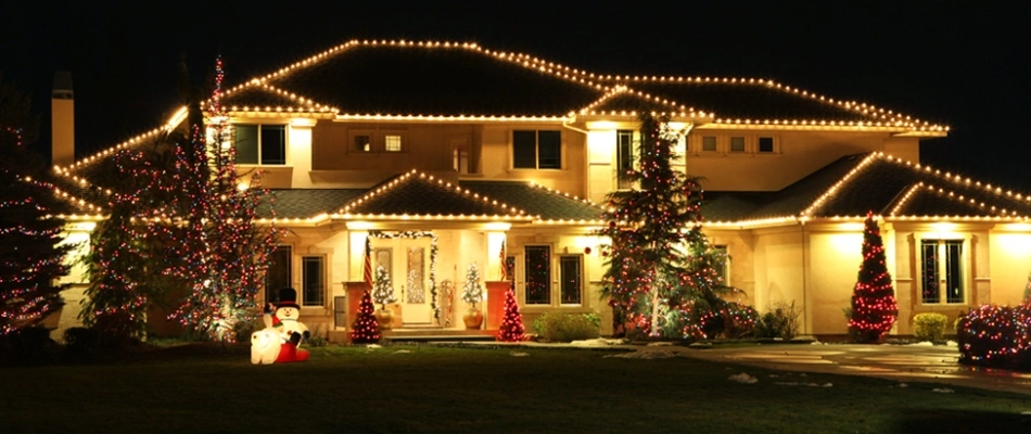 Large home with holiday lighting installed around home and landscaping in Broad Ripple, IN.